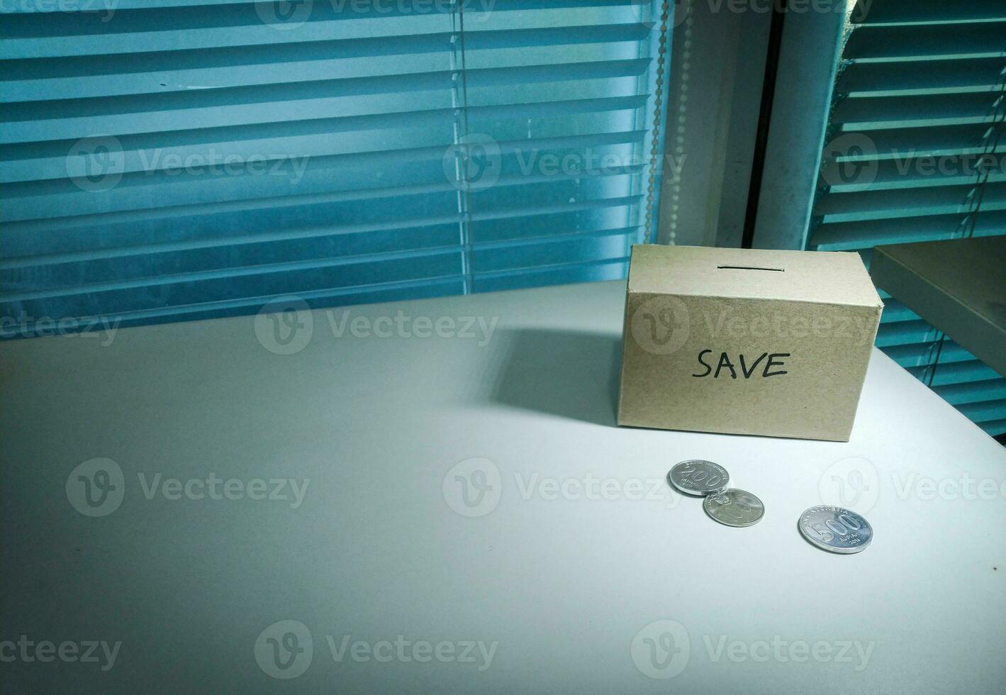 A box of savings and coins stacked on a table, for background purpose photo