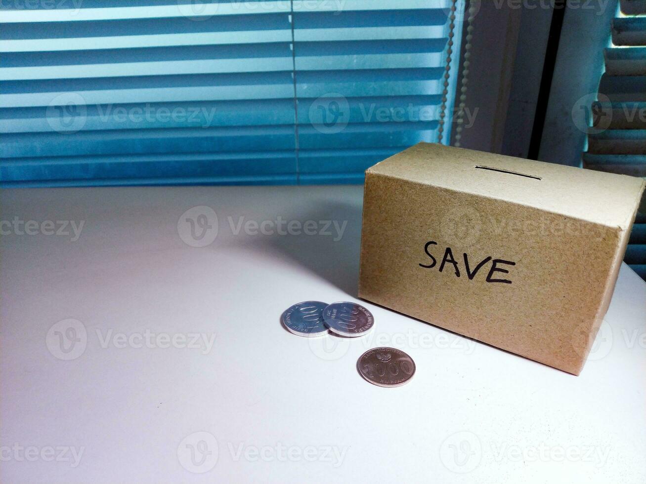 A box of savings and coins stacked on a table, for background purpose photo