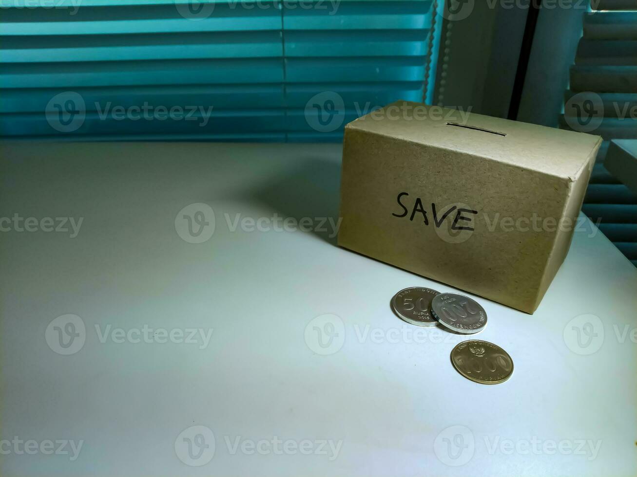 A box of savings and coins stacked on a table, for background purpose photo