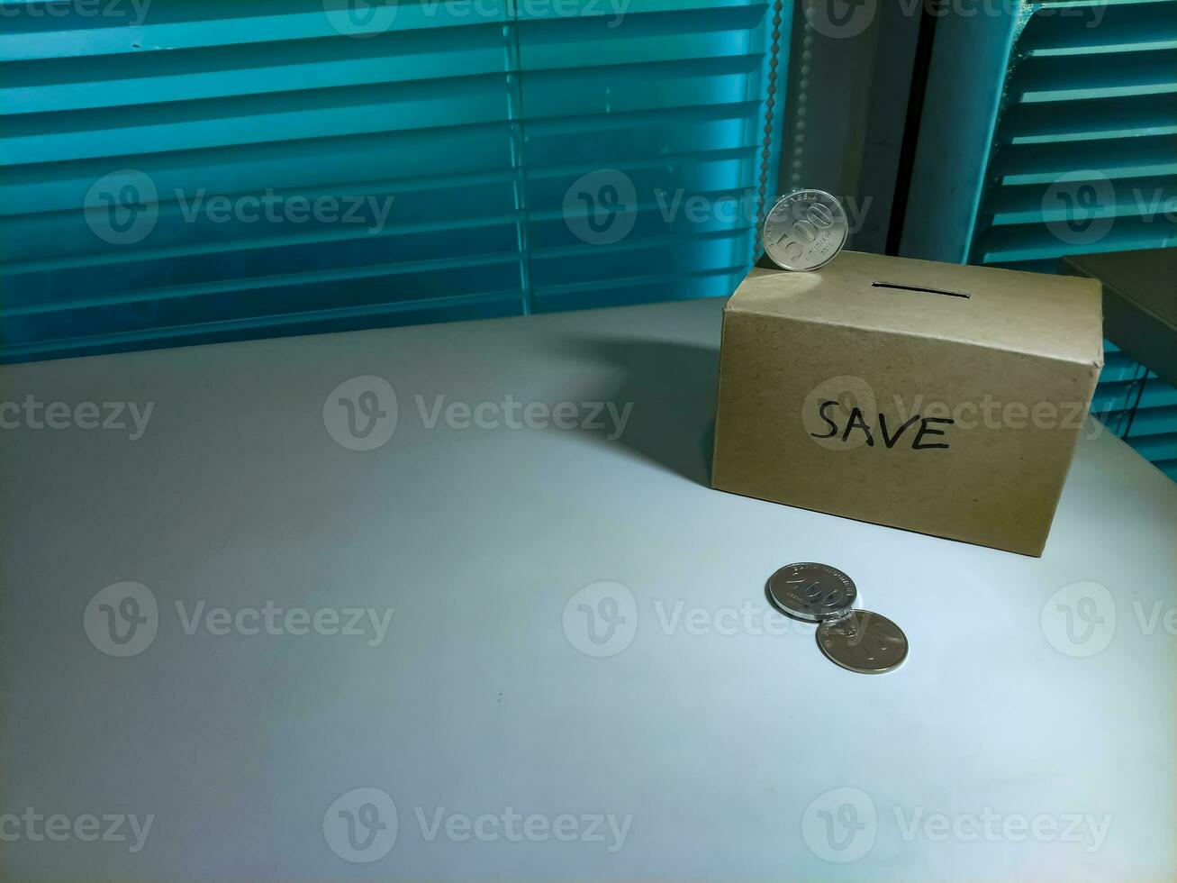 A box of savings and coins stacked on a table, for background purpose photo