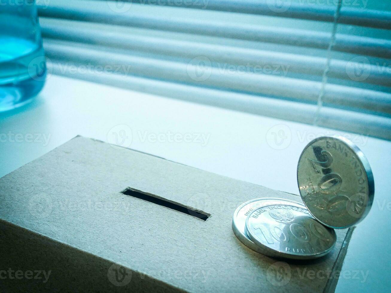 A Close up of box of savings and coins stacked. photo