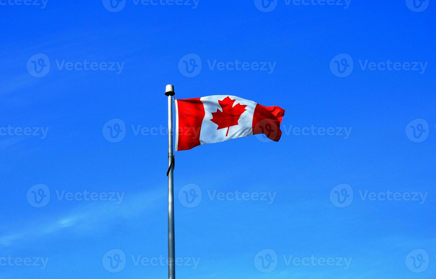 The flag of Canada on blue sky  background close up. photo