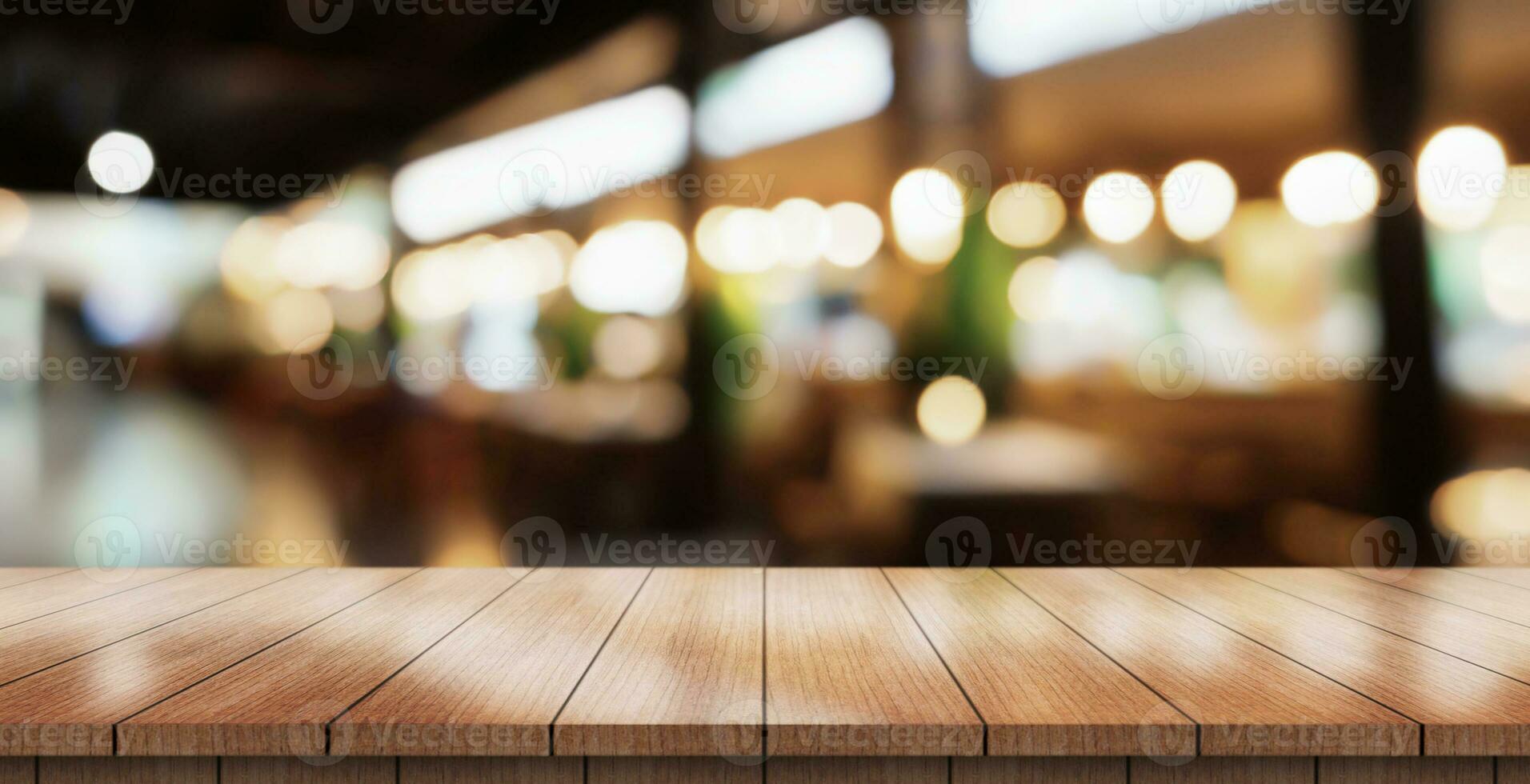 Empty wooden table top with lights bokeh on blur restaurant background. photo