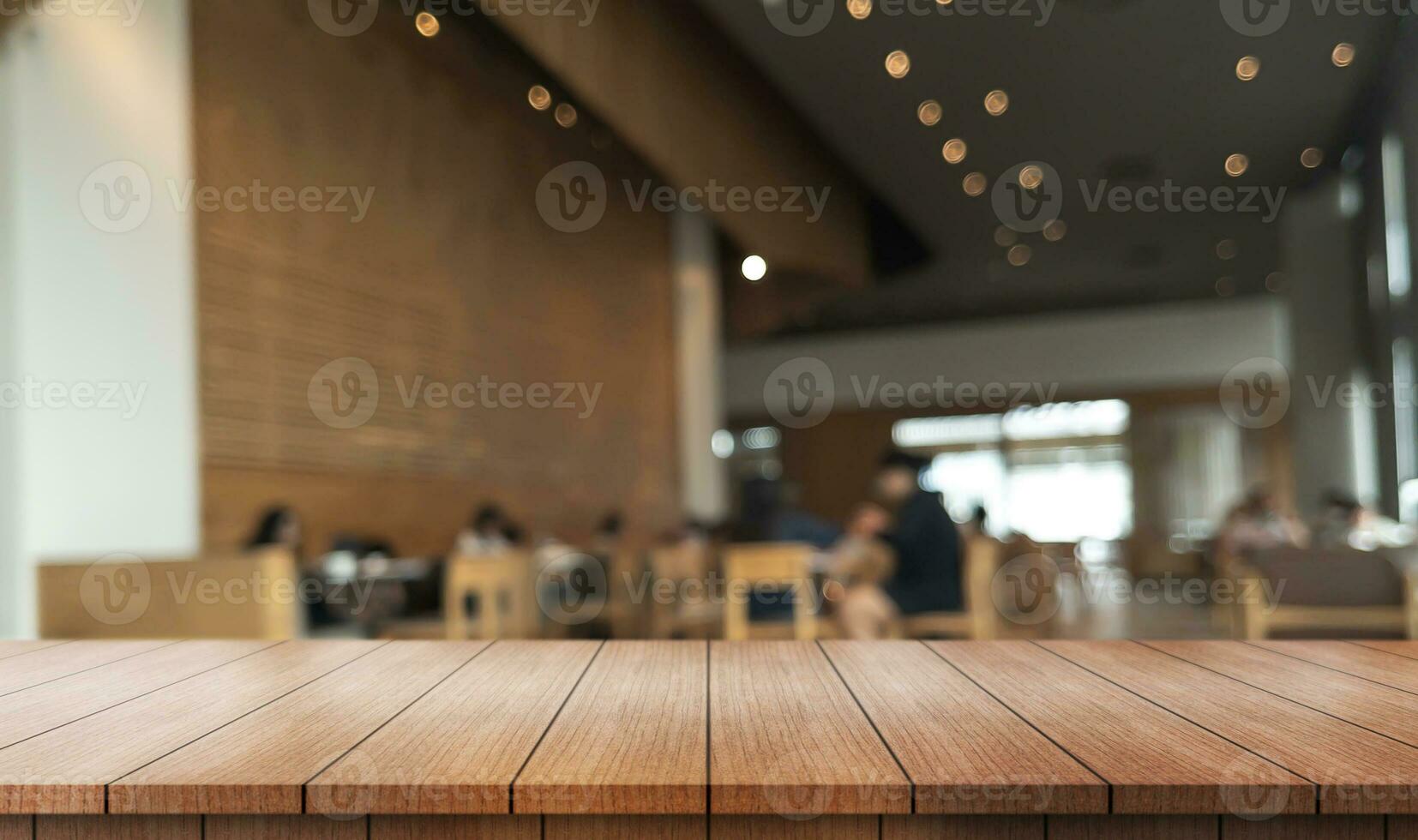 Empty wooden table top with lights bokeh on blur restaurant background. photo