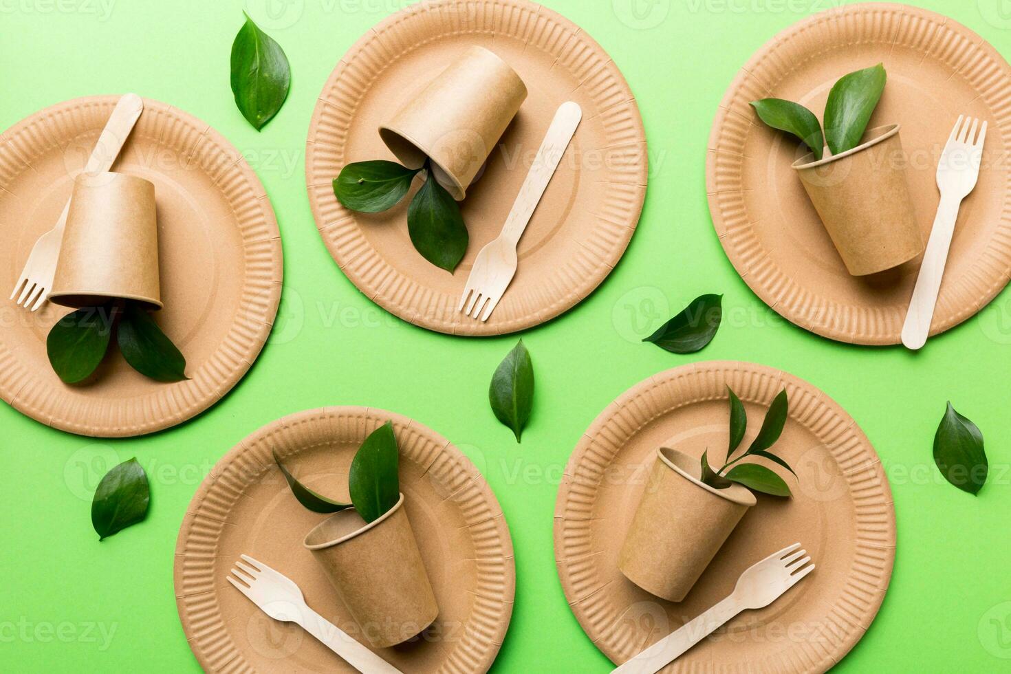 set of empty reusable disposable eco-friendly plates, cups, utensils on light white colored table background. top view. Biodegradable craft dishes. Recycling concept. Close-up photo