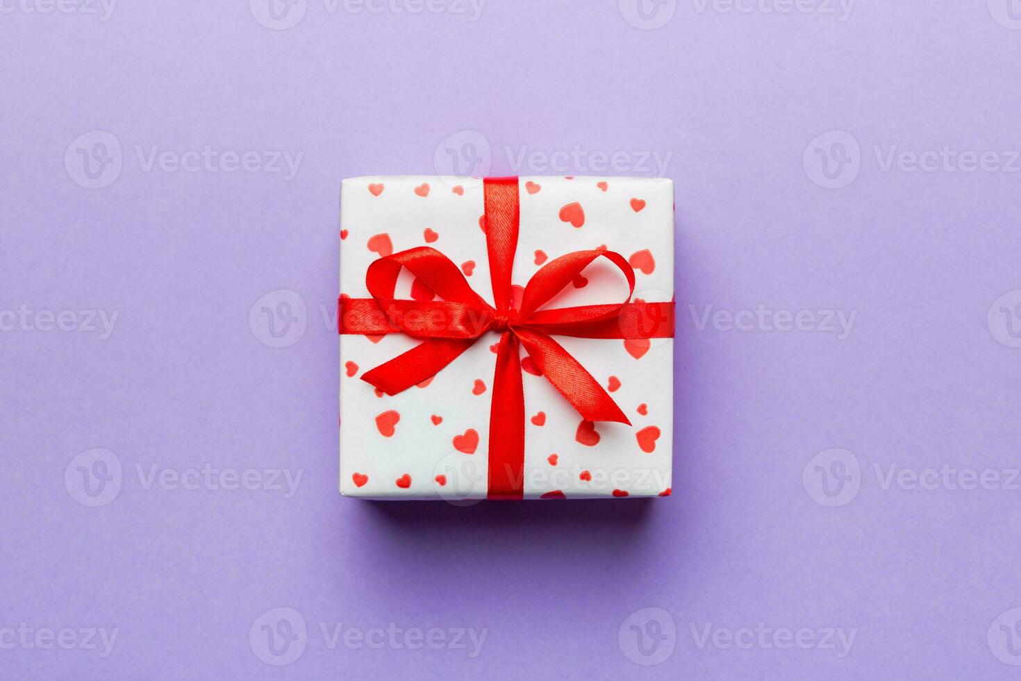 Valentine day composition red  gift box with bow and heart. Christmas present. View from above. Holday greeting card photo