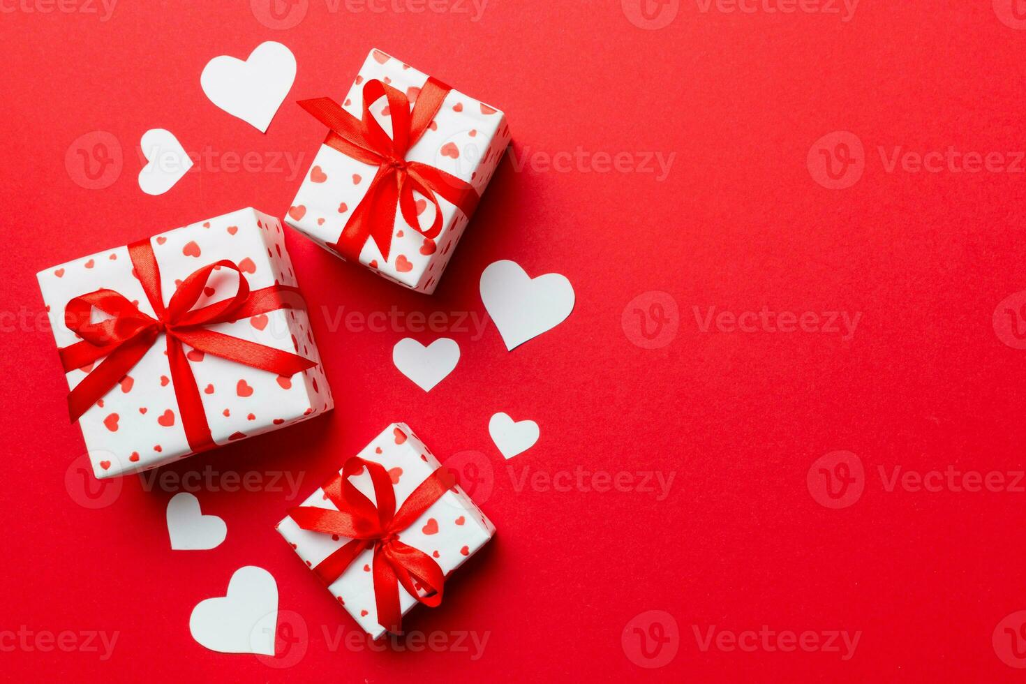 Valentine day composition red  gift box with bow and heart. Christmas present. View from above. Space for text. Holday greeting card photo