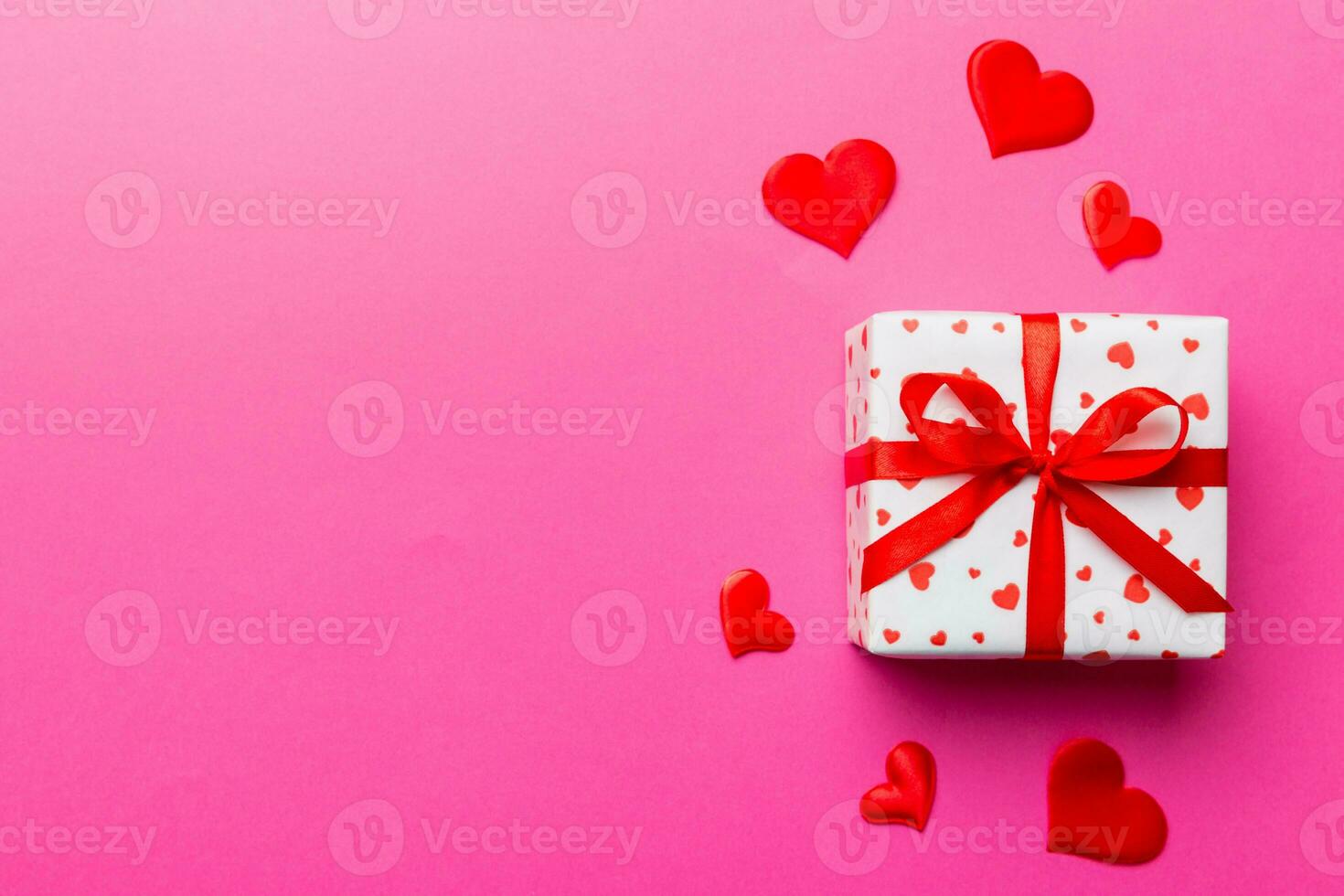 Valentine day composition red  gift box with bow and heart. Christmas present. View from above. Space for text. Holday greeting card photo