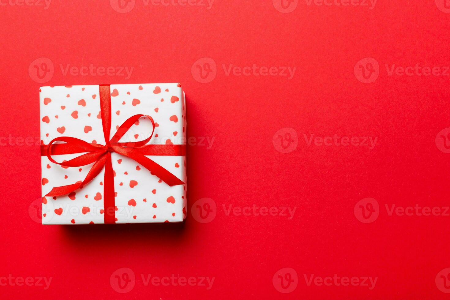 Valentine day composition red  gift box with bow and heart. Christmas present. View from above. Space for text. Holday greeting card photo