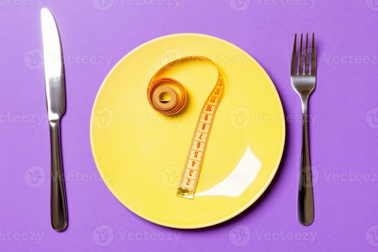 Question mark made of measuring tape on round plate on purple background. Top view of hesitation and diet concept photo