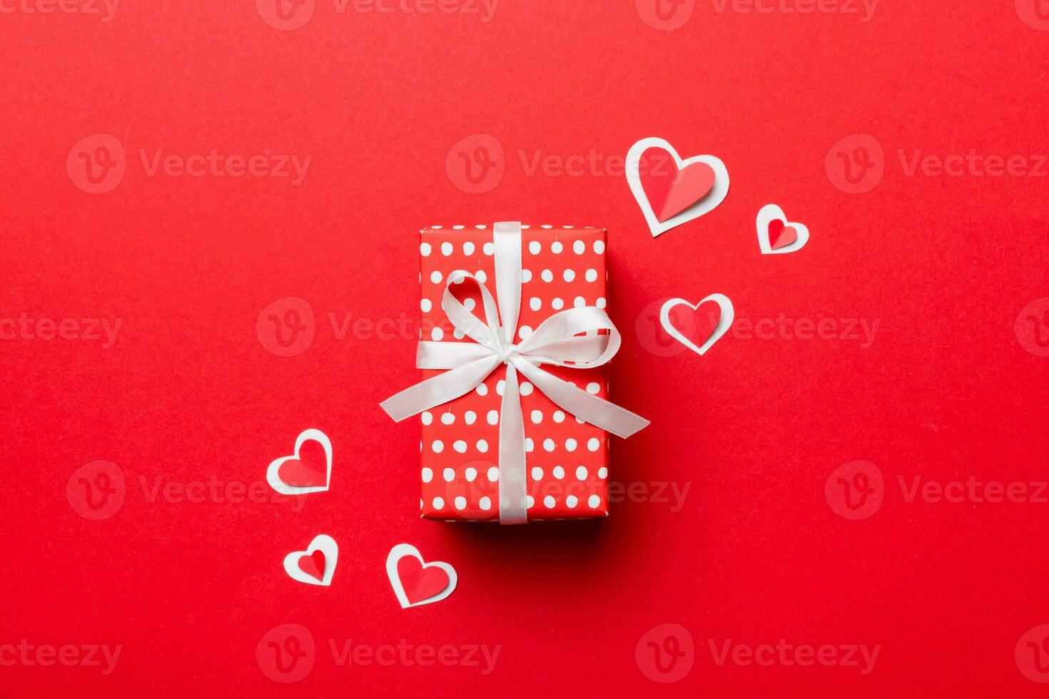 Valentine day composition red gift box with bow and heart. Christmas present. View from above. Holday greeting card photo