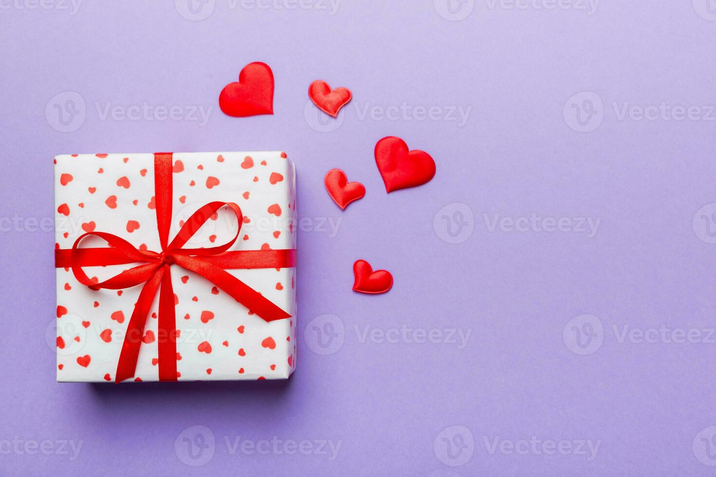 Valentine day composition red  gift box with bow and heart. Christmas present. View from above. Space for text. Holday greeting card photo