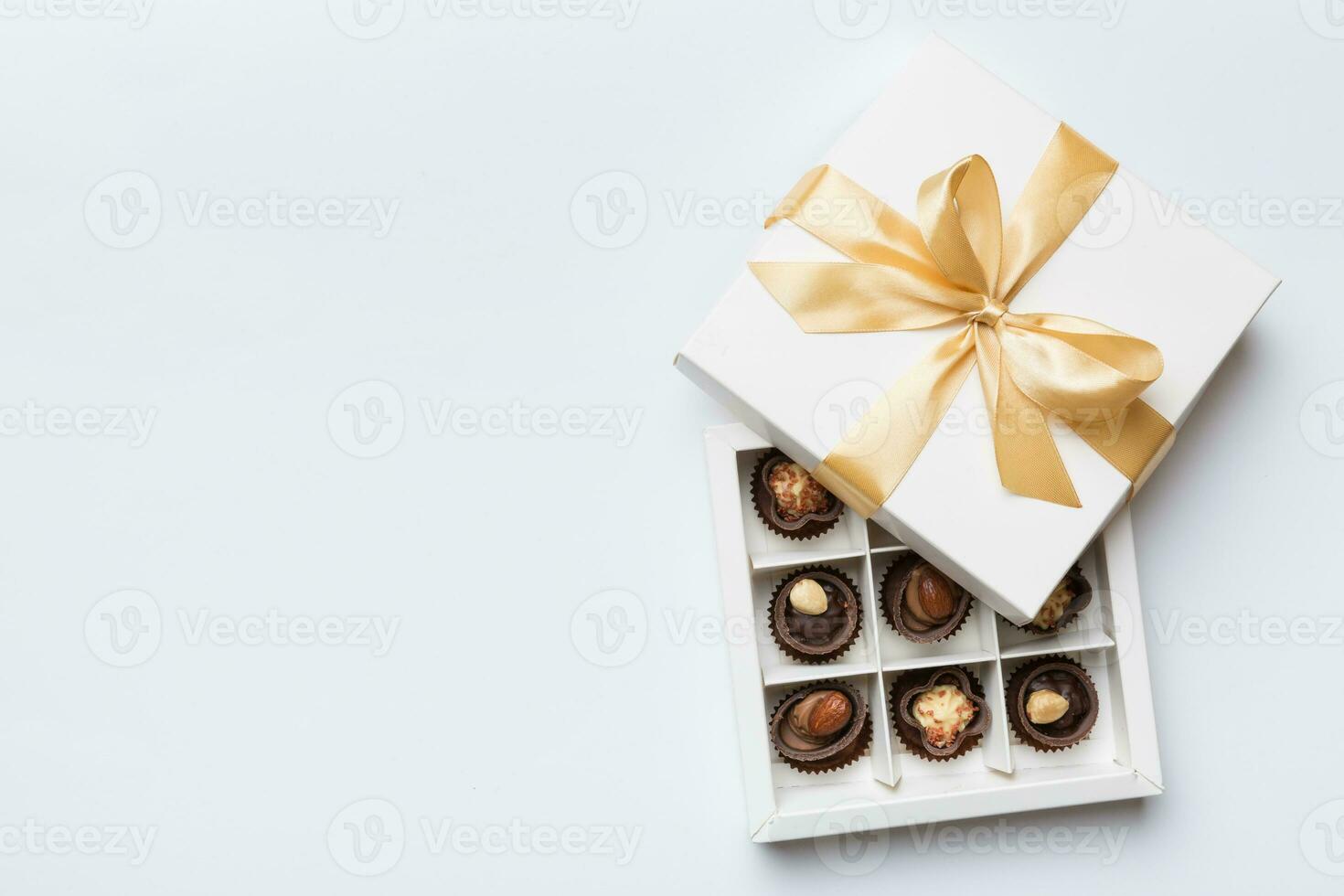 White box with chocolates candies and golden tape. top view with copy space photo