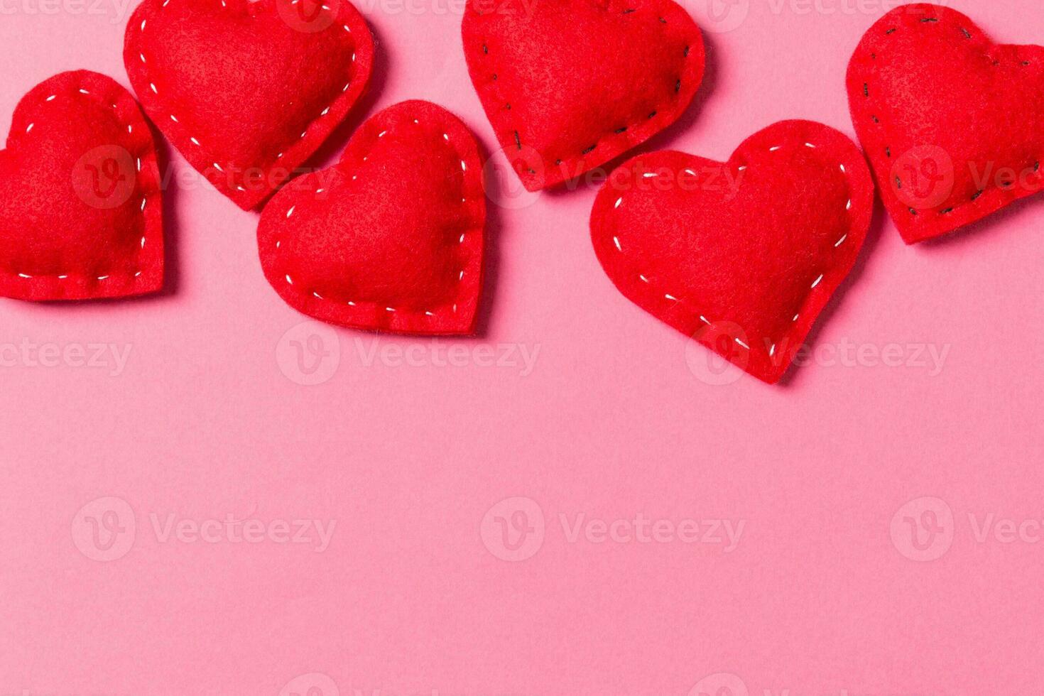 Composition of textile red hearts on colorful background with empty space for your design. Top view of St. Valentine's day concept photo