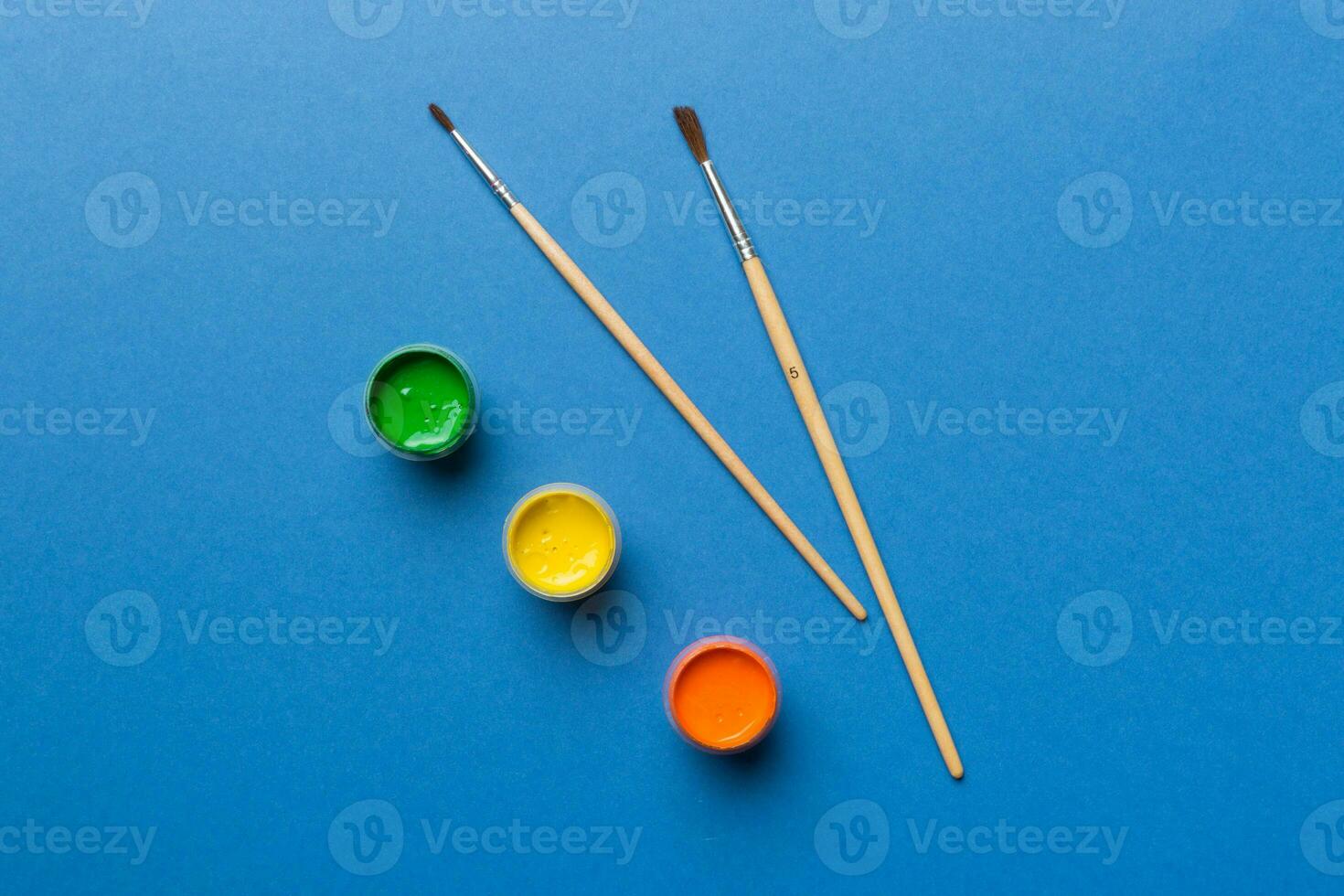art palette with paint and brushes, close up. Top view with empty space. workplace for creativity. home teaching concept drawing photo