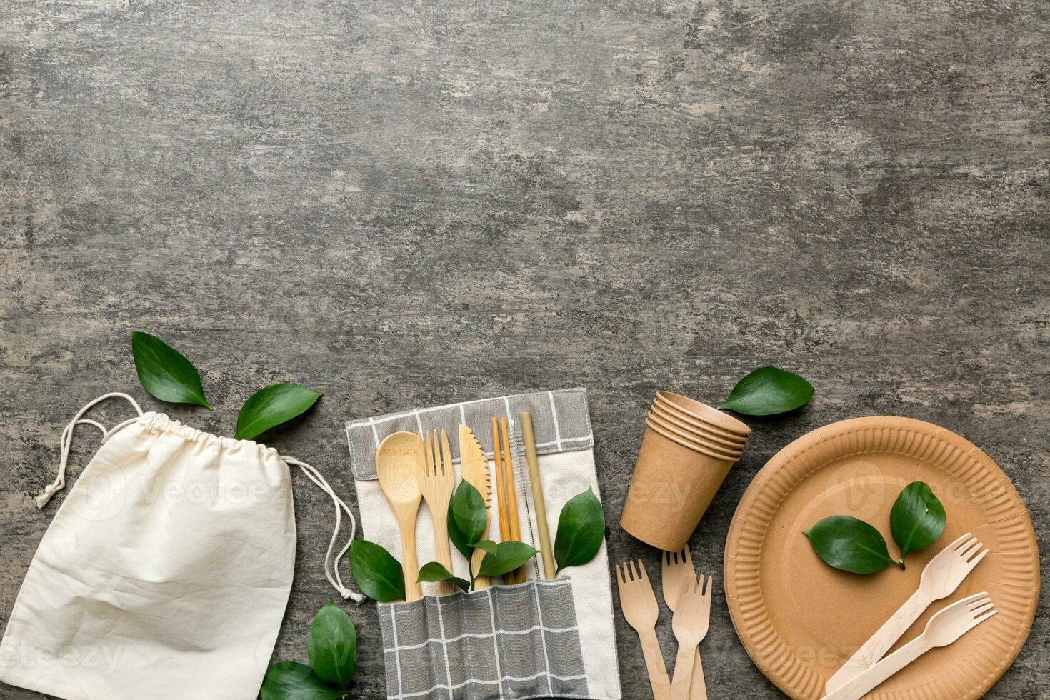 set of empty reusable disposable eco-friendly plates, cups, utensils on light white colored table background. top view. Biodegradable craft dishes. Recycling concept. Close-up photo