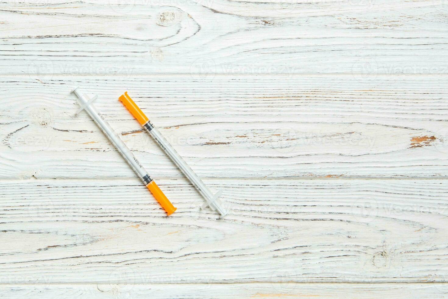 Top view of insulin syringe prepared for injection at wooden background. Diabetes concept with copy space photo