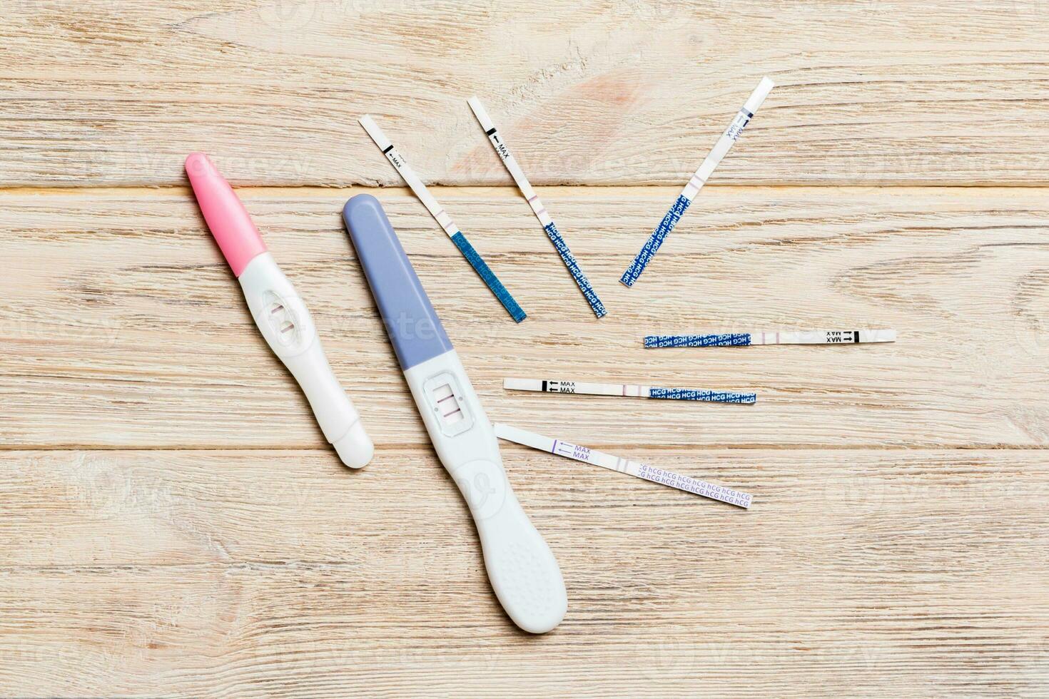 Colored Pregnancy test on wooden background, top view with copy space photo