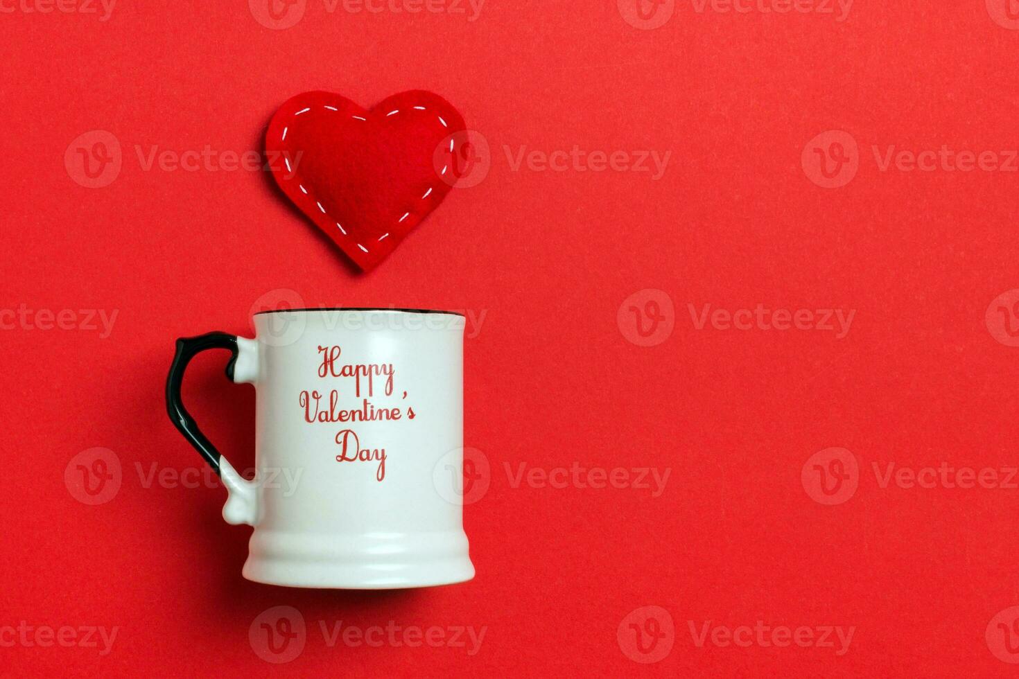 Holiday composition of red hearts falling out from a cup on colorful background. Top view of Saint Valentine's Day concept with copy space photo