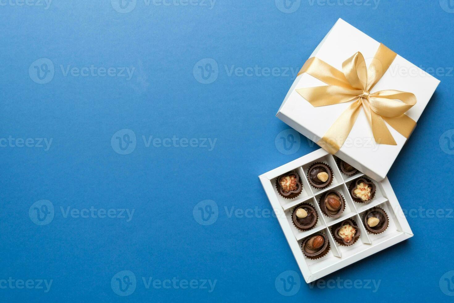 White box with chocolates candies and golden tape. top view with copy space photo