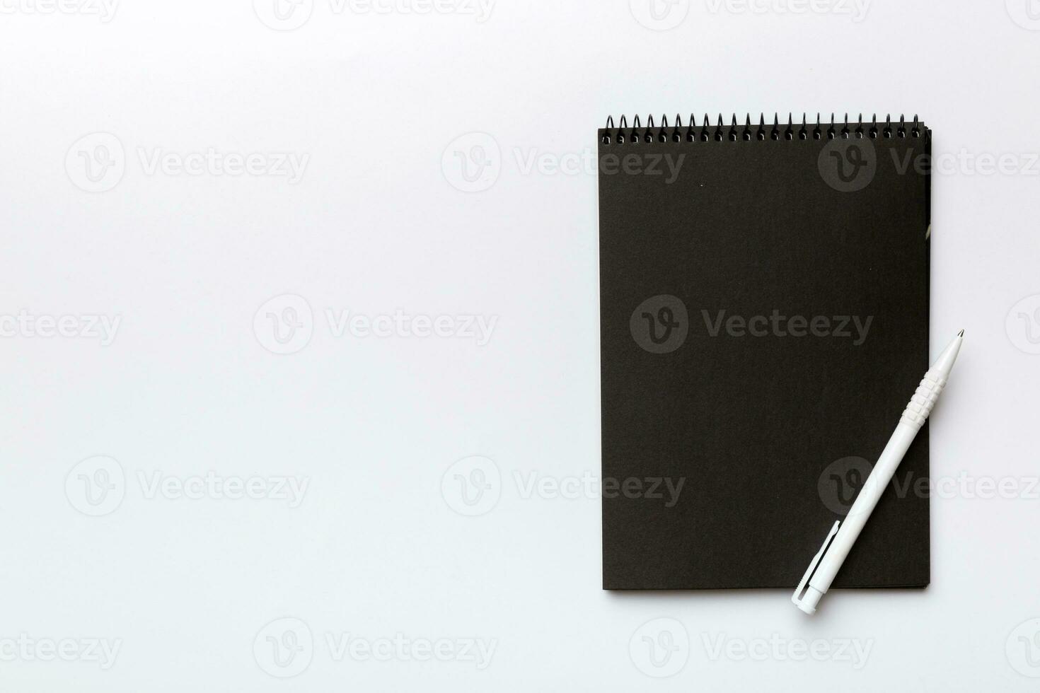 school notebook on a colored background, spiral black notepad on a table Top view photo