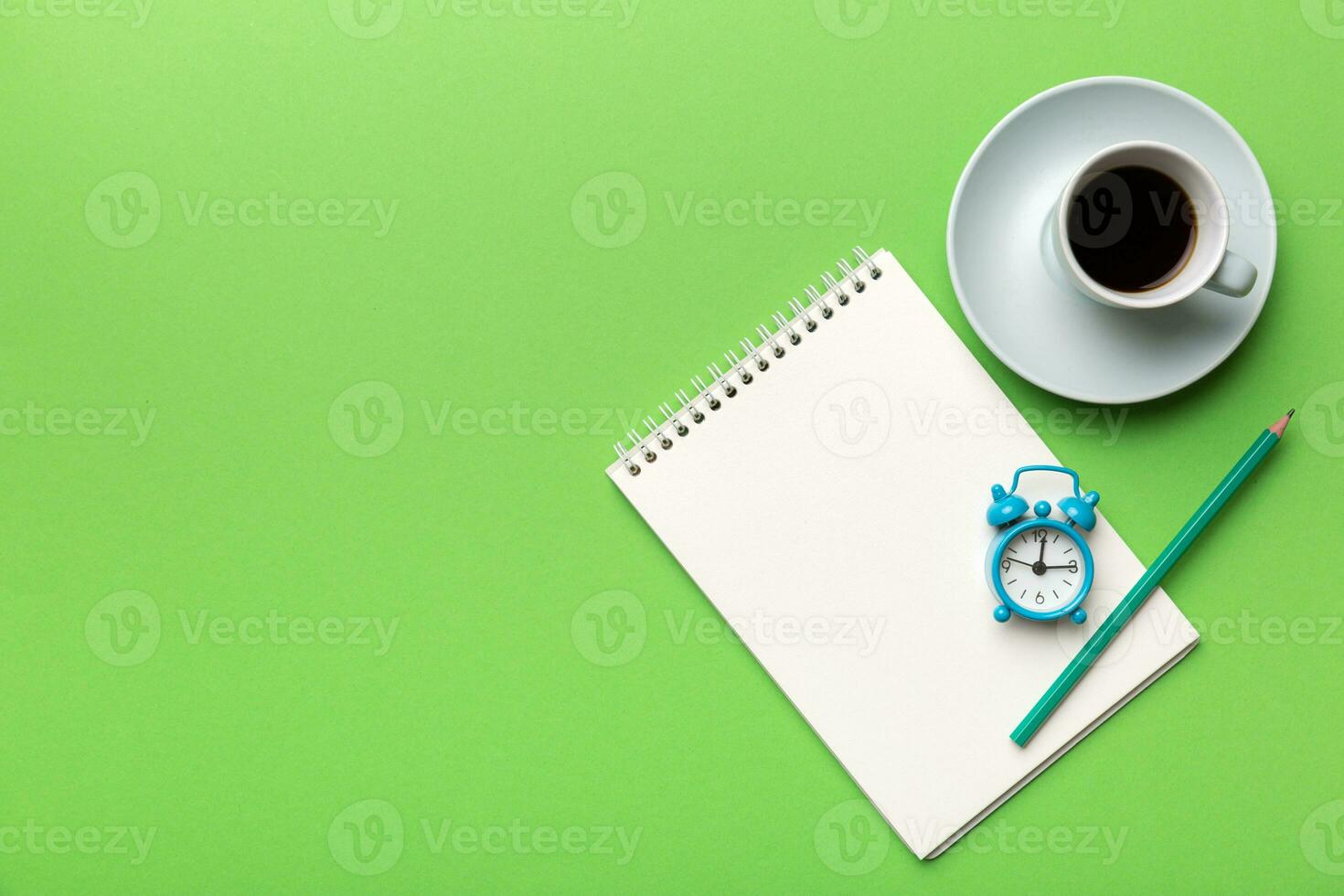 Modern office desk table with notebook and other supplies with cup of coffee. Blank notebook page for you design. Top view, flat lay photo