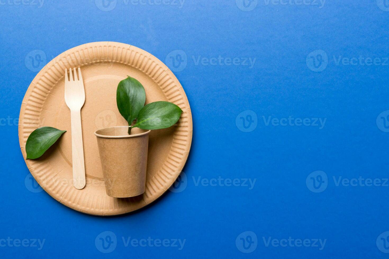 set of empty reusable disposable eco-friendly plates, cups, utensils on light white colored table background. top view. Biodegradable craft dishes. Recycling concept. Close-up photo