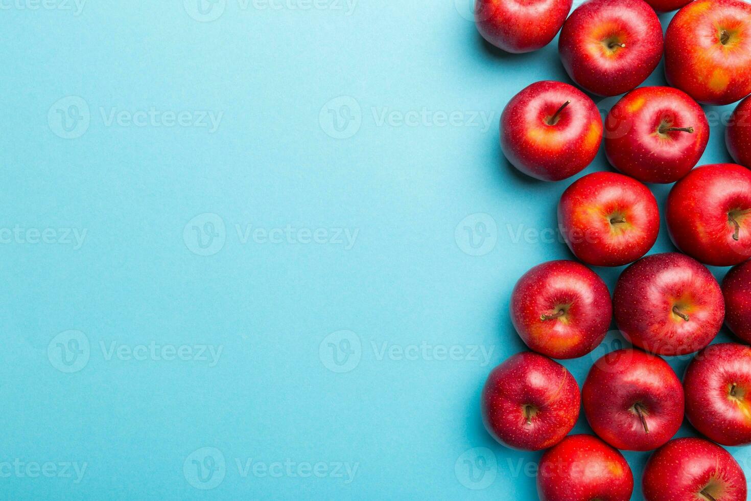 Many red apples on colored background, top view. Autumn pattern with fresh apple above view with copy space for design or text photo