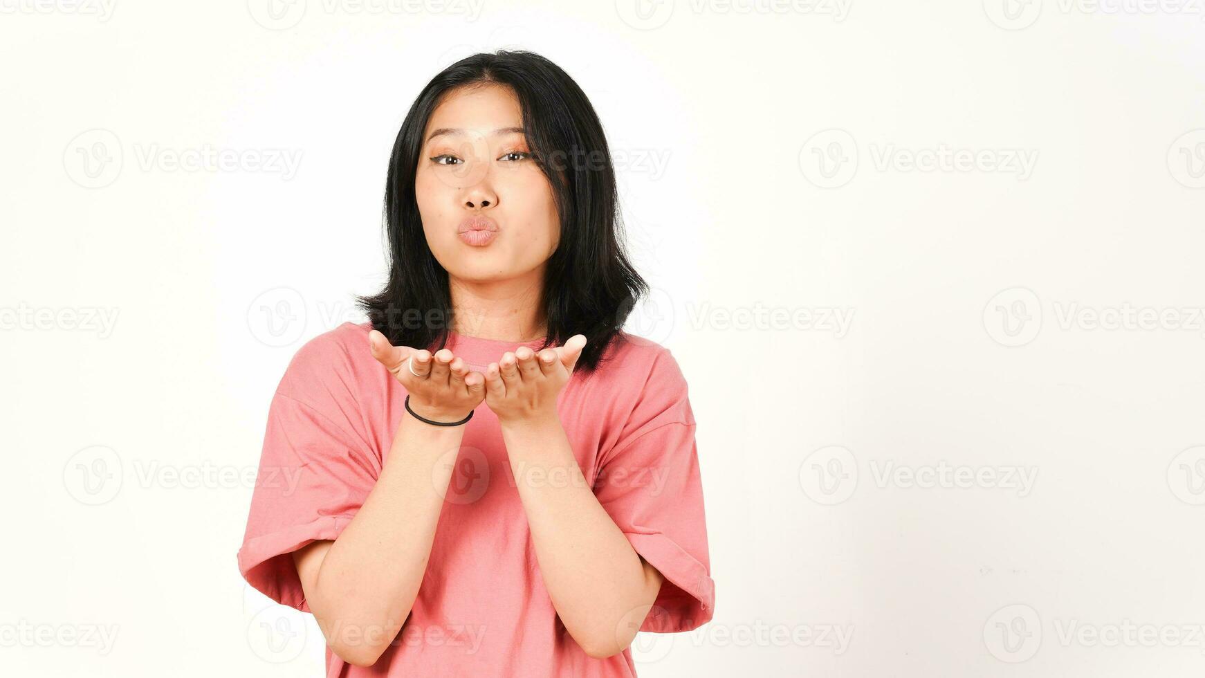 joven asiático mujer en rosado camiseta soplo un Beso en aislado blanco antecedentes foto