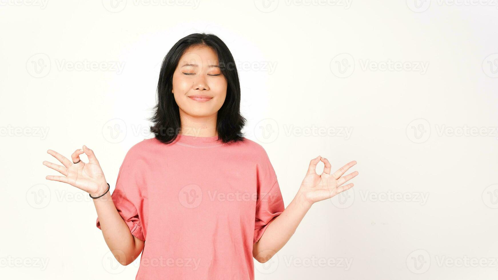 Young Asian woman in pink t-shirt lotus hand position on isolated white background photo