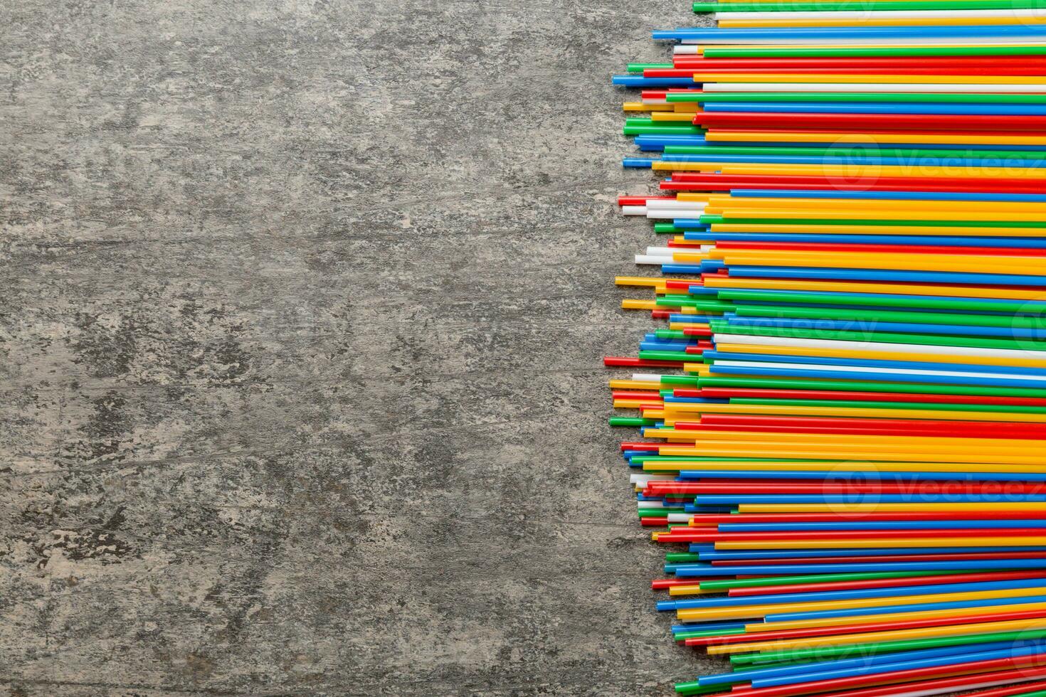 Heap of colorful plastic drinking straws on Colored background, flat lay. Copy Space for text photo