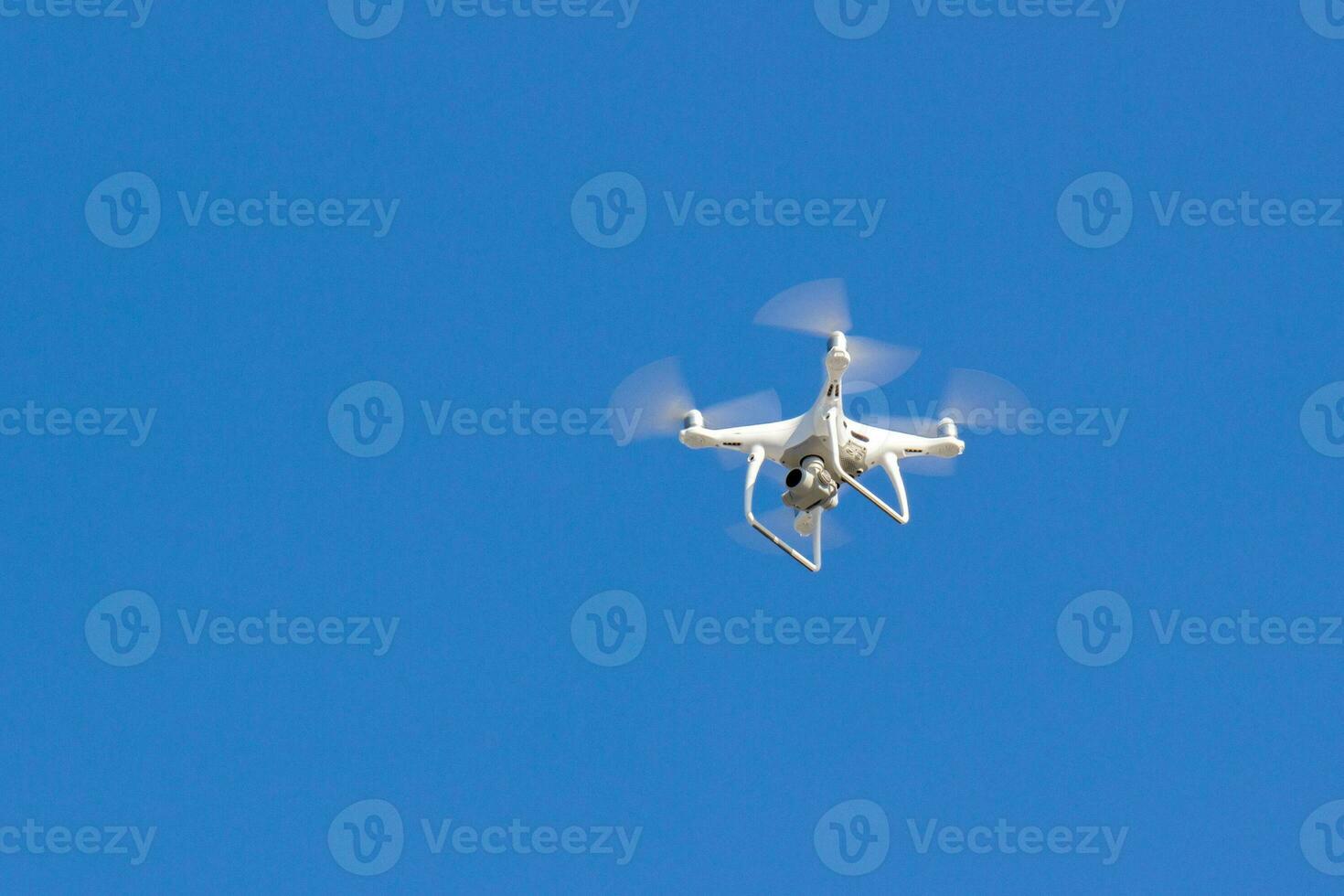 Quadcopter drone is flying in the blue sky. Unmanned aerial vehicle. Remote video shooting from a height. Modern digital camera photo