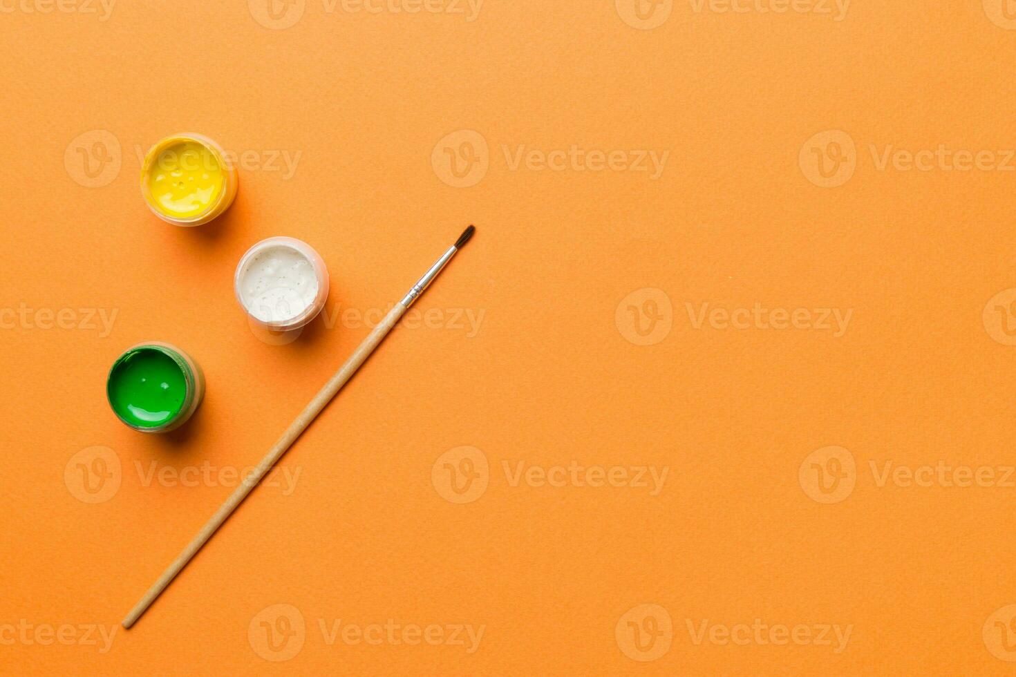 art palette with paint and brushes, close up. Top view with empty space. workplace for creativity. home teaching concept drawing photo