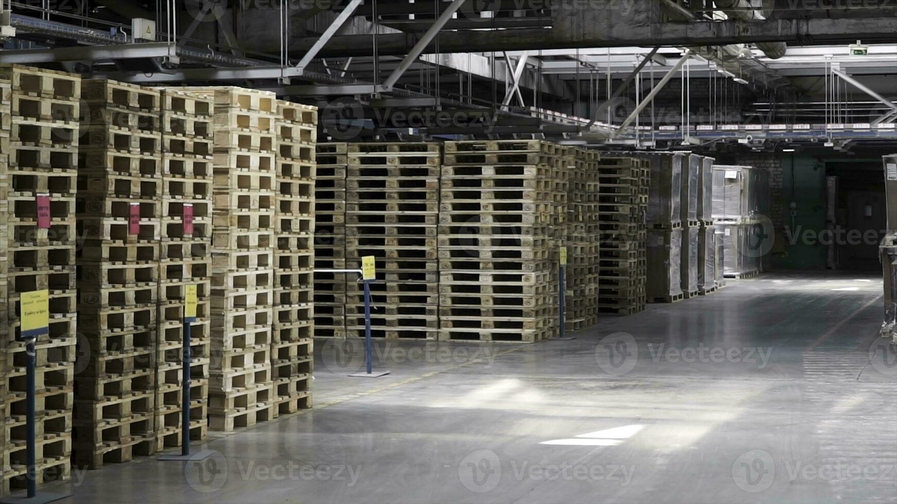 Warehouse with racks and shelves, filled with cardboard boxes, wrapped in foil on wooden pallets. Clip. Large and light warehouse, cargo storage in wooden boxes. Wooden pallets and cardboard boxes photo