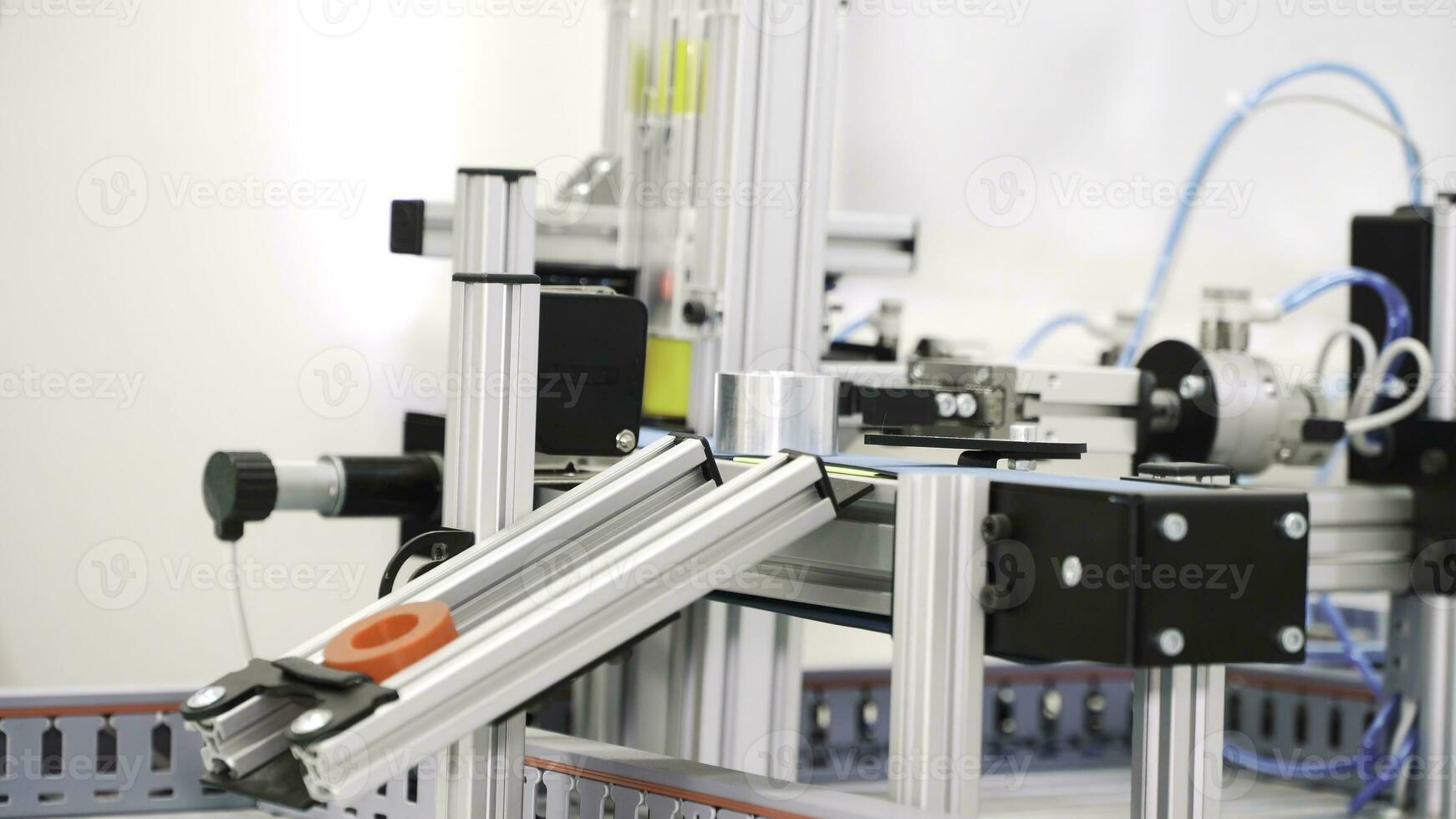 The robotic arms holding hollow tubes and putting them on the conveyor line. Scene. Automated machine placing sleeve details on the production lines. photo