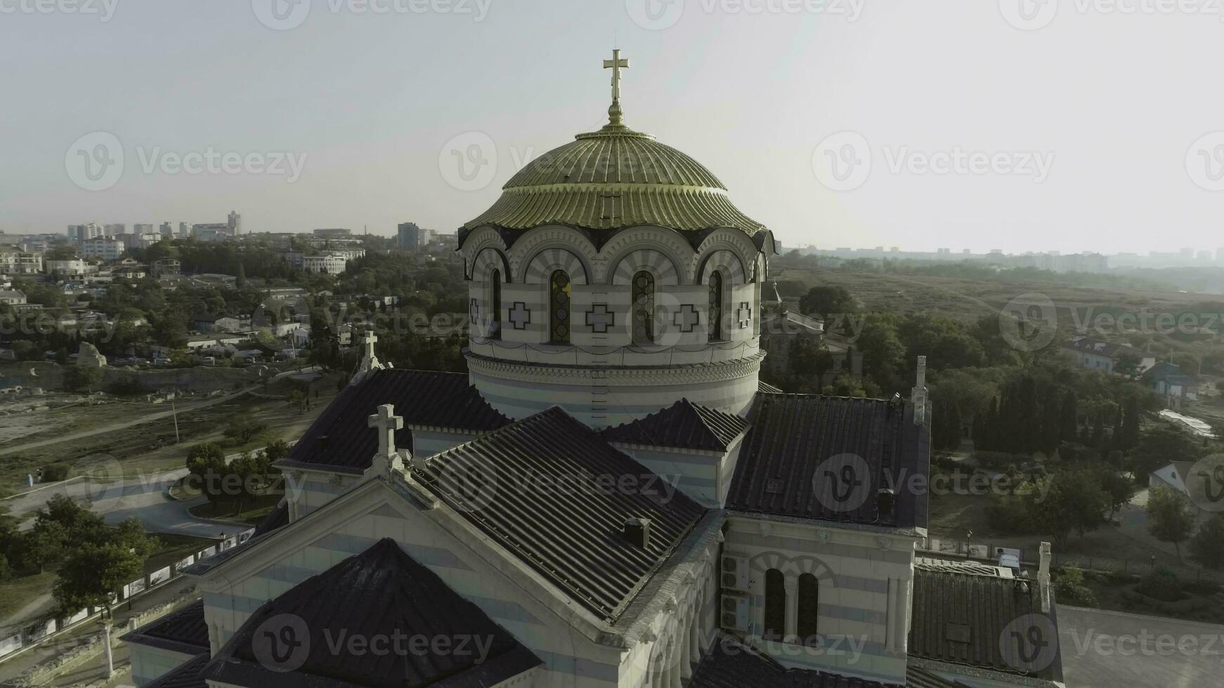 View of the big white church with golden domes in front of beautiful river, spring Vologda, Russia. Shot. Beautiful aerial from the bird's eye view for the big church on the river bank. photo