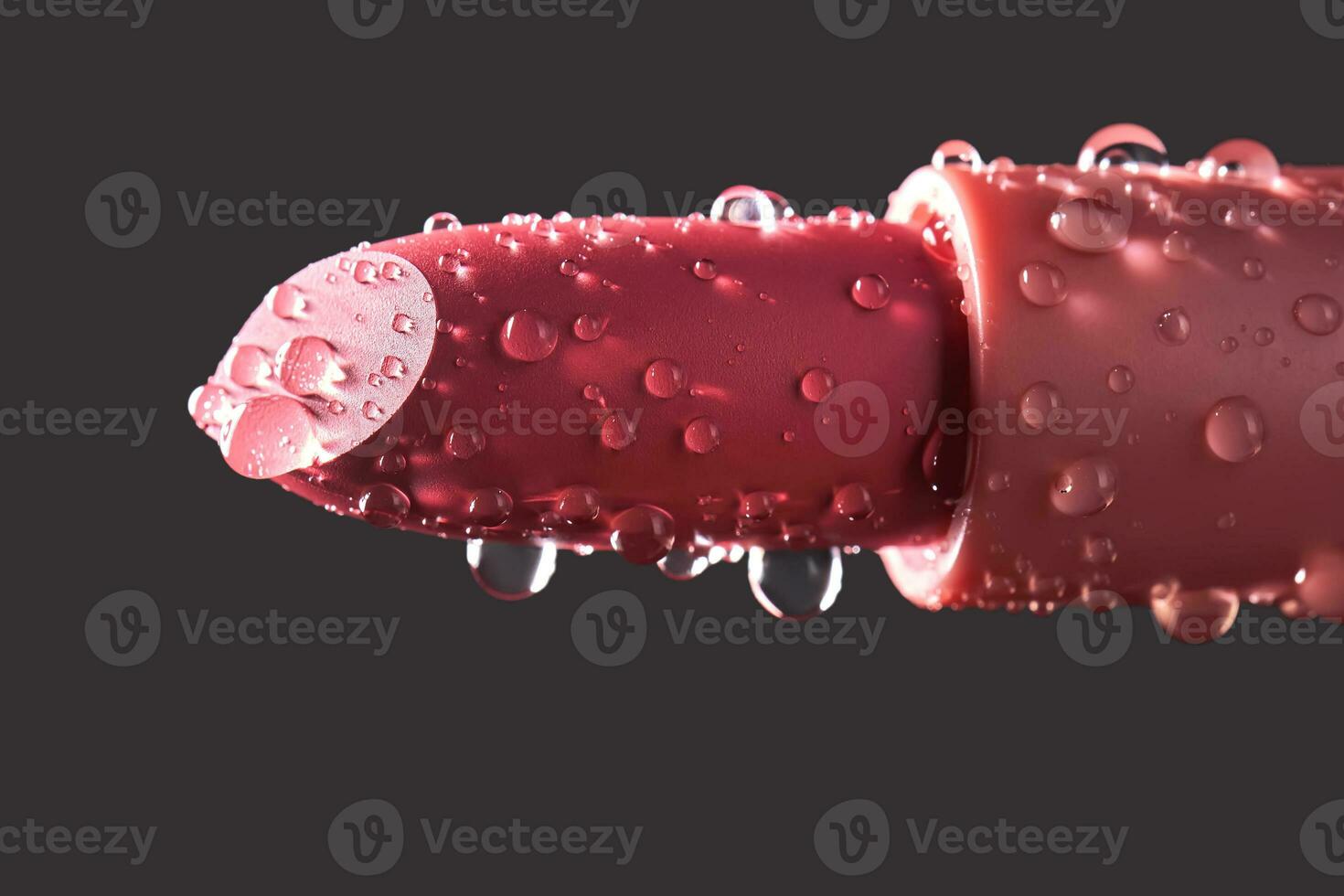 Red lipstick with water drops on a dark background. photo