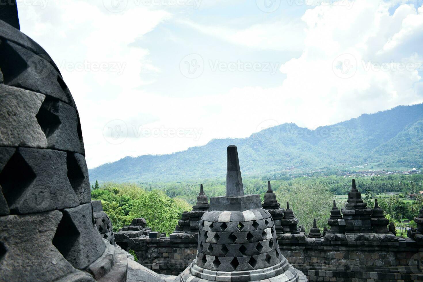 The beauty of Borobudur temple, with a backdrop of green forests and blue skies photo