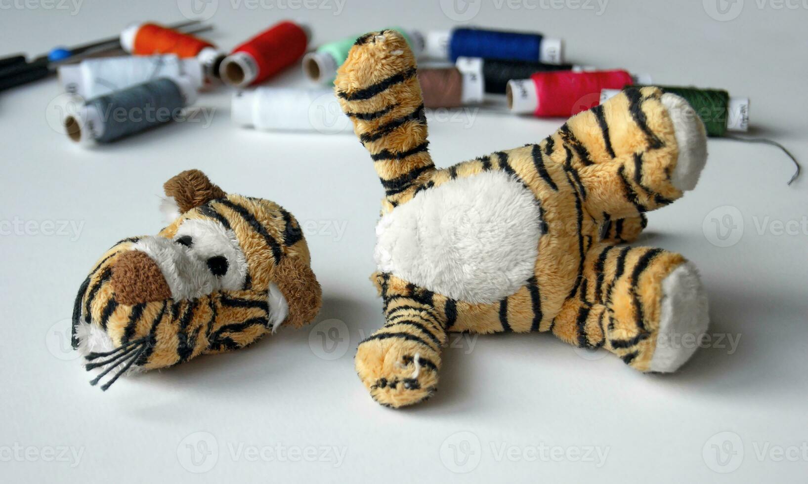 Plush tigger with a torn head. Sewing kit. photo