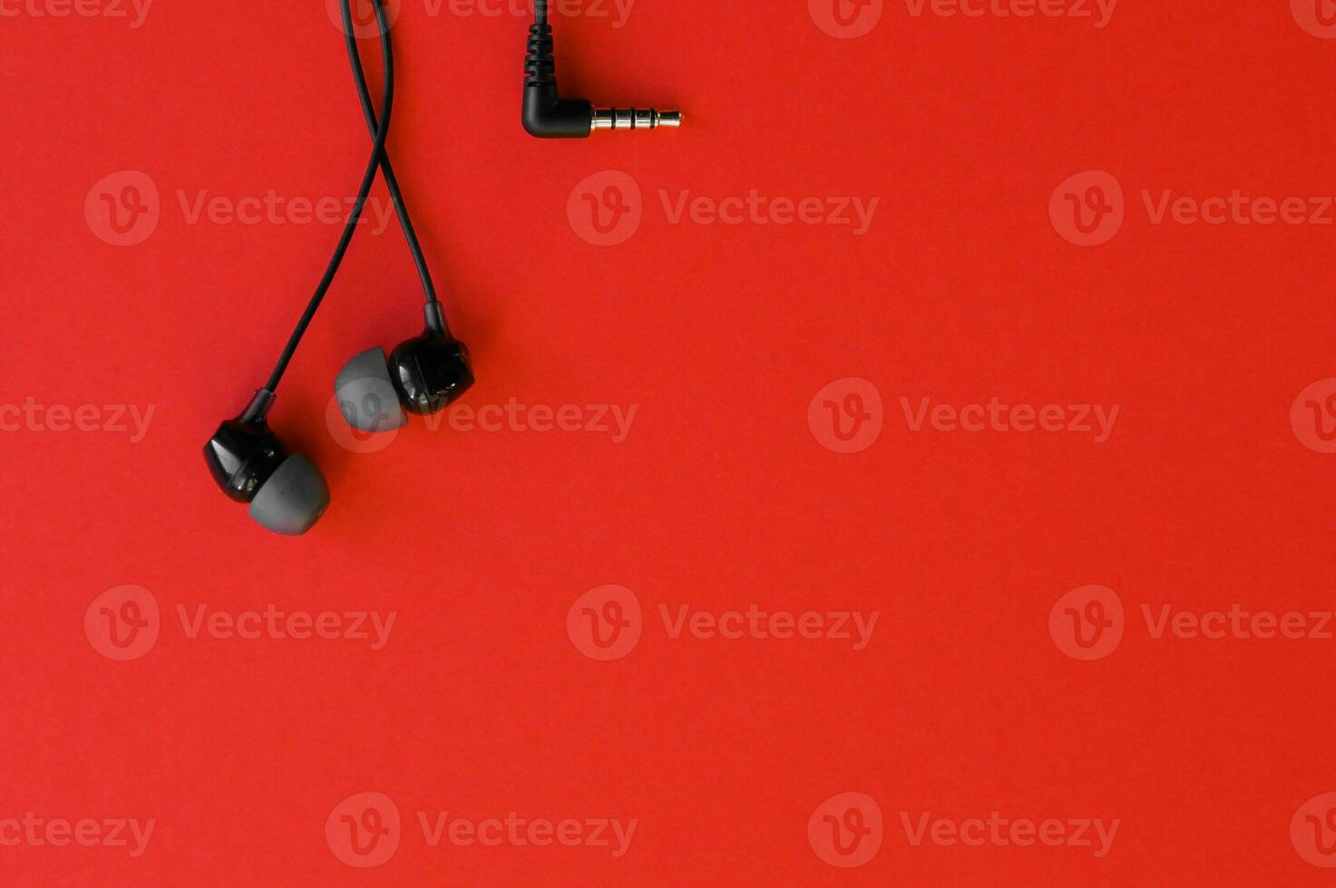 auriculares desde el teléfono son en un rojo antecedentes. foto