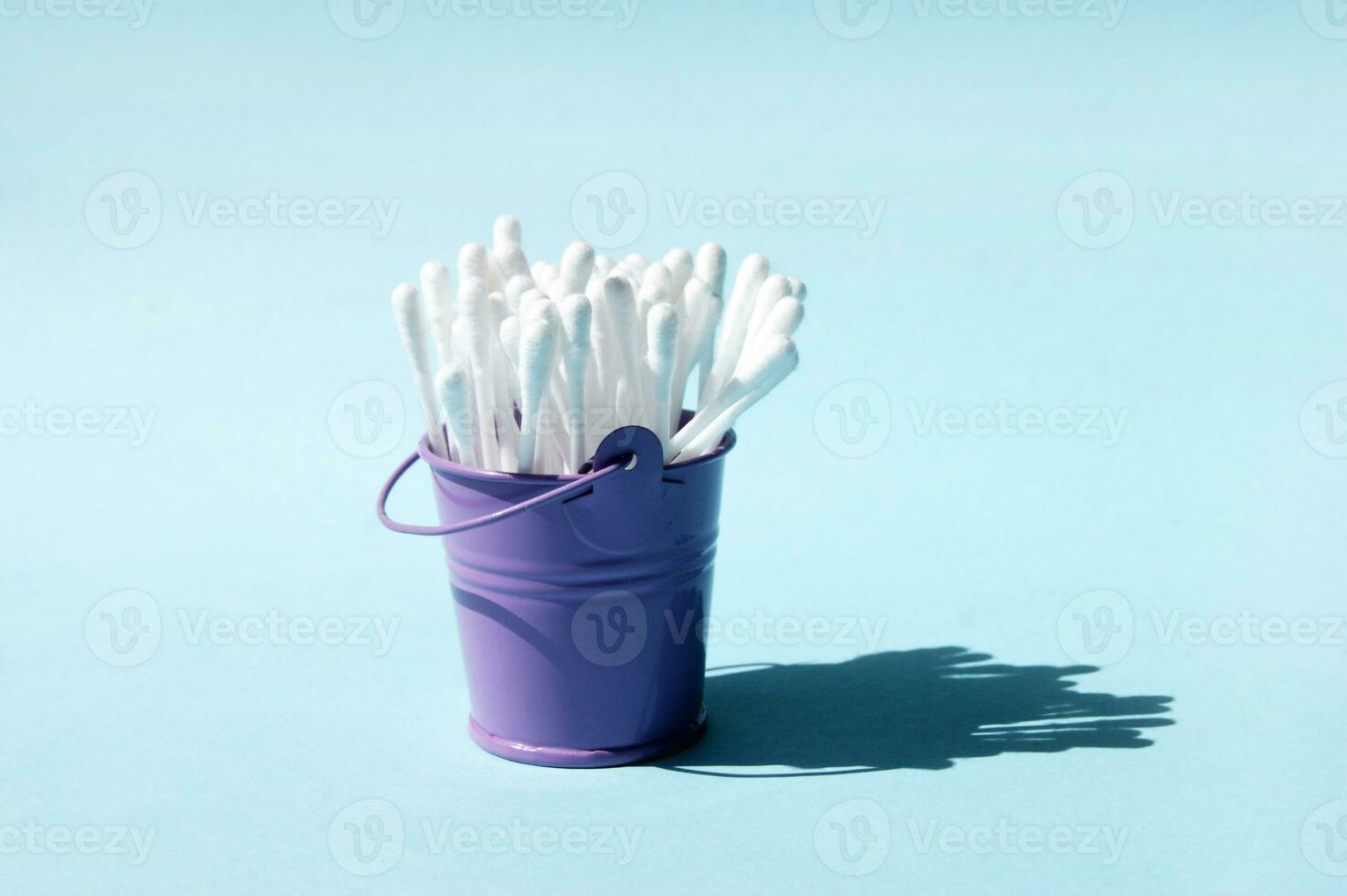 A lot of clean ear sticks in a miniature metal purple bucket. photo