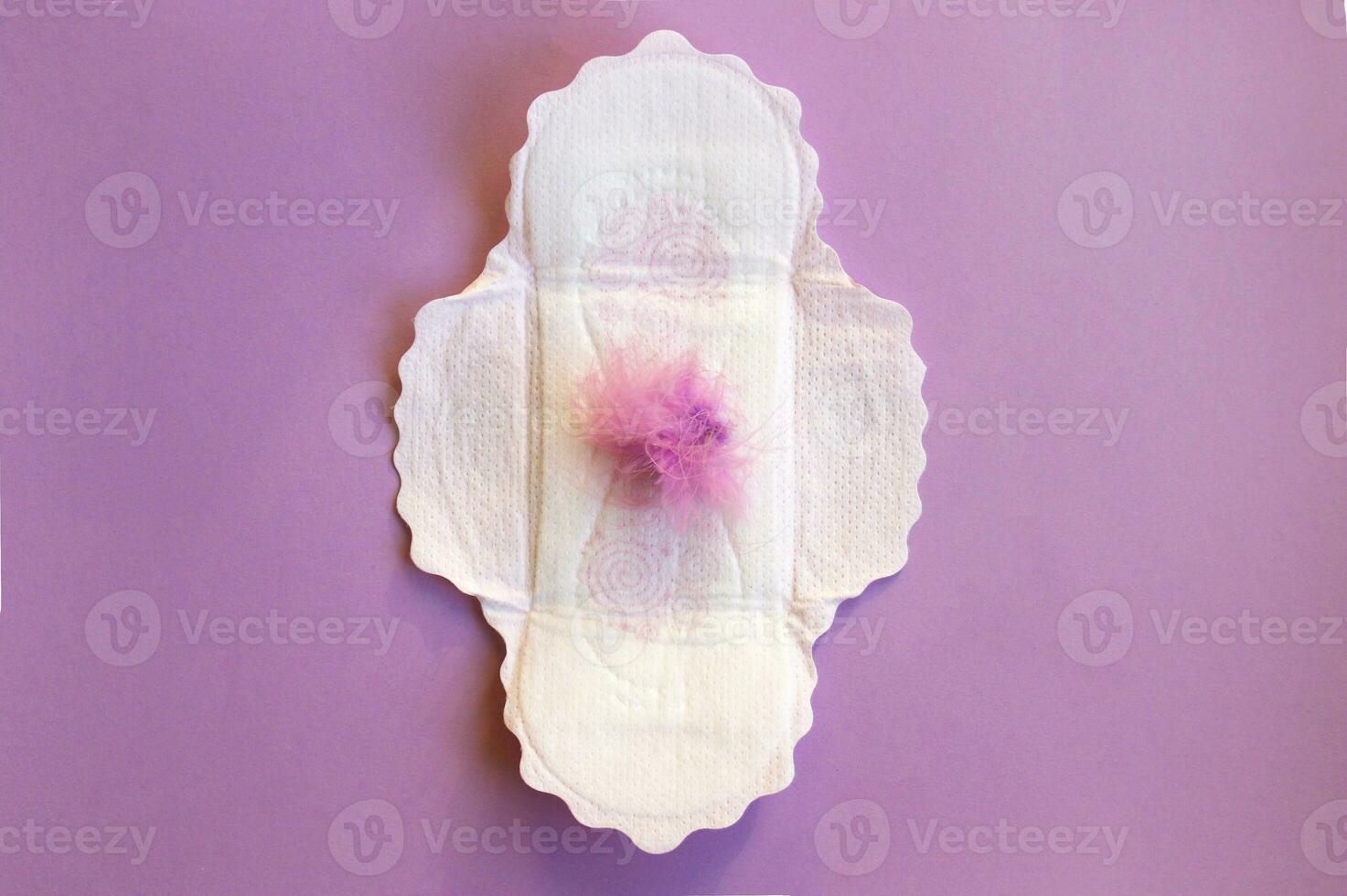 Menstrual pads on menstruation period calendar with on lilac background. photo