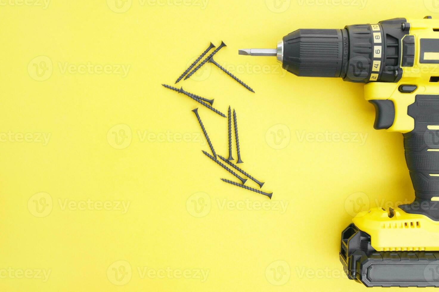 The yellow-black screwdriver on a yellow background, screws. photo
