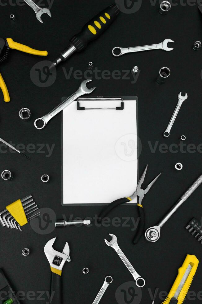 Notebook for writing, around various work tools on a black background. photo