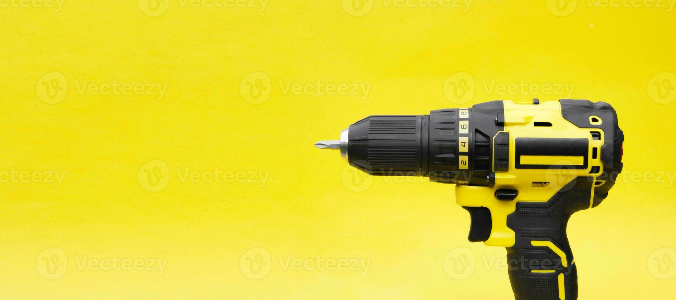 The yellow-black screwdriver on a yellow background. photo