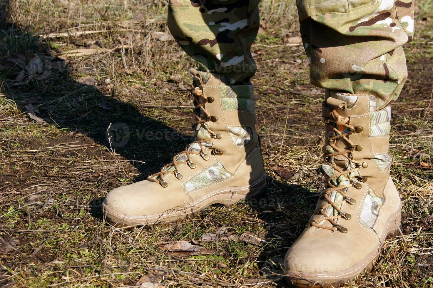 Soldier in camouflage pants and army boots. photo