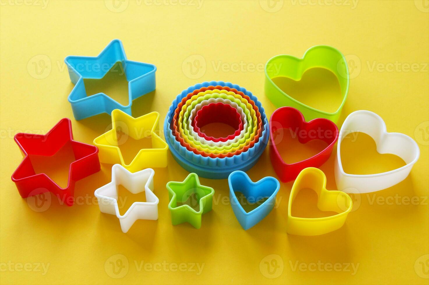 Plastic molds of multi colors for making cookies in the shape of a openwork circle, stars and hearts. photo