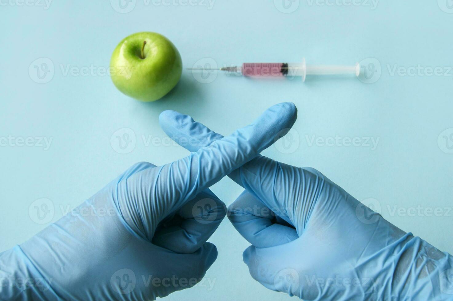 The sign of the cross of fingers, as a sign of protest GMO with vegetables and fruits. photo