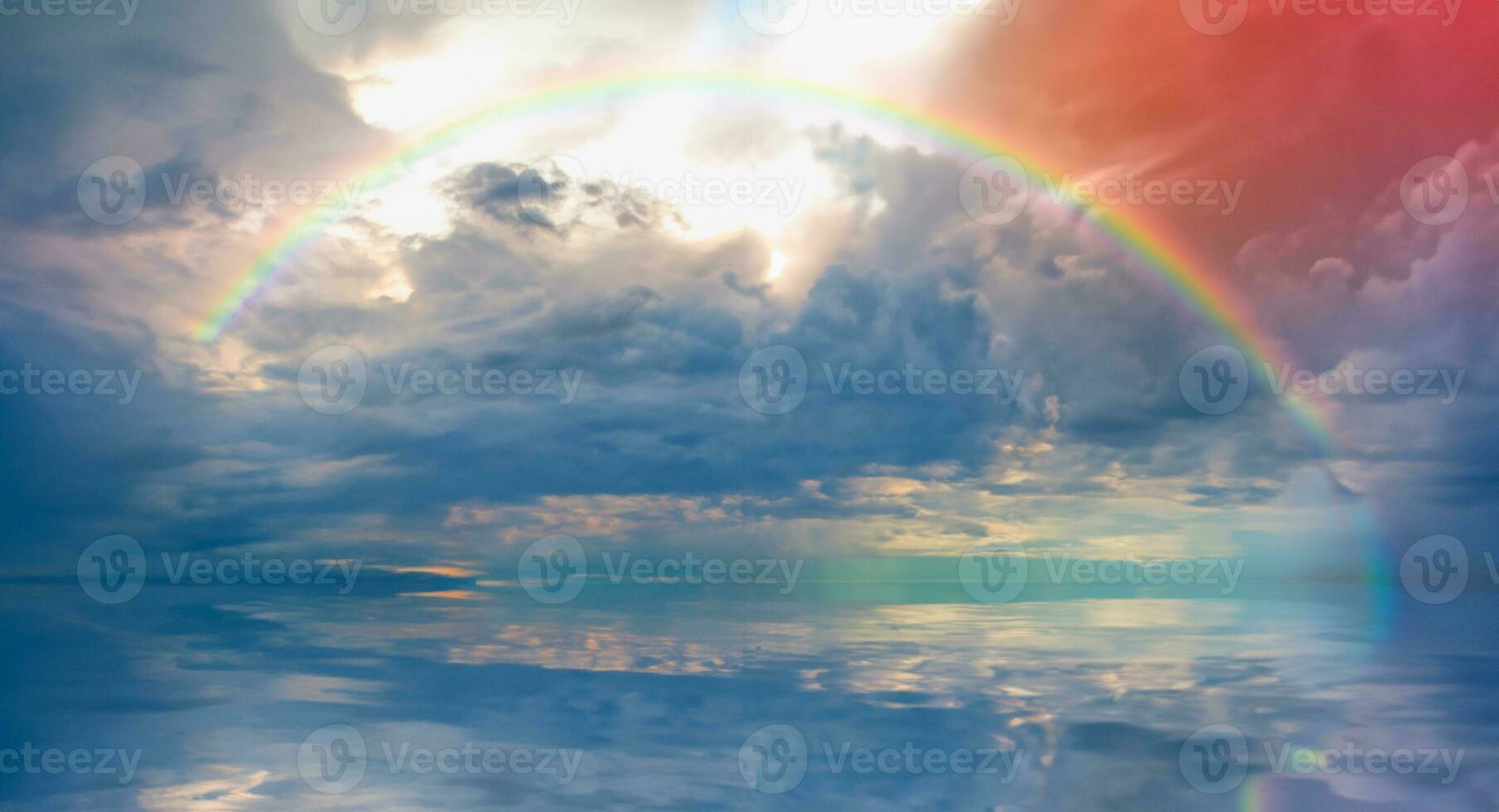 Stormy sea before storm with amazing rainbow at sunset photo