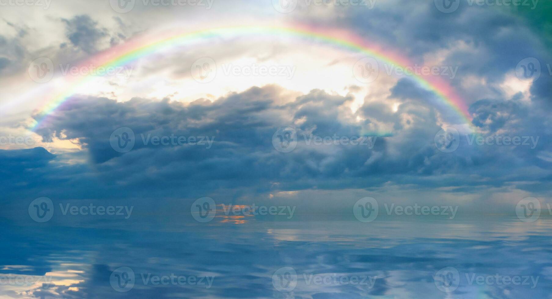 Stormy sea before storm with amazing rainbow at sunset photo